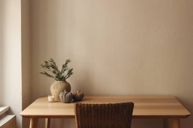 Zarif bir sonbahar iç mimarisi. Zeytin dallı vazo. Ahşap masa üzerinde küçük balkabakları. Merkez ofis. Scandi 'nin içi. Şükran Günü, Cadılar Bayramı dekoru, cam tutacağında mum. Bej duvar modeli