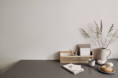 Modern yaz, sonbahar natürmort fotoğrafı. Eski ahşap taburede kuru festuca otu olan gri seramik vazo. Beyaz duvar arka planı. Boş kopyalama alanı. Zarif yaşam tarzı dekoratif sahne, modaya uygun iç dekorasyon.