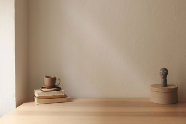 Sanatsal boho natürmort. Bir fincan çay, kahve, eski kitaplar. Boho busta heykeli, heykel. Yuvarlak tekstil hediye kutusu. Bej duvar arka plan modeli. Boş kopya alanı, zarif iç mekan oturma odası.