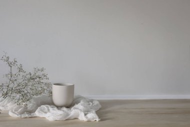 Zarif, minimal kahvaltı, hayat devam ediyor. Çay fincanı ile sıcak kahve seti, narin çigila, bebek nefesli çiçekler ahşap masada. Mantar fırlatma, beyaz duvar arka planı. Doğum günü, düğün kavramı.