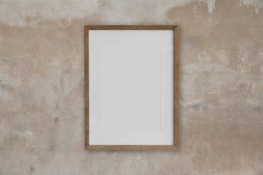 Bej desenli beton duvarda boş bir tahta çerçeve modeli. Odada boş poster şablonu var. Ahşap çerçeve modeli, boş baskı arkaplanı, galeri tasarımı