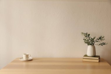 Akdeniz kahvaltısı hala hayat dolu. Bir fincan kahve, çay, ahşap masada eski kitaplar. Yeşil zeytin dallı seramik vazo, yapraklar. Zarif çalışma alanı, ev ofisi. İskandinav iç mekanları