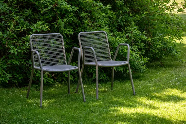 スプリングガーデンの金属椅子 ピクニックやバードウォッチングのための金属庭の家具 ストック写真