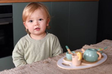 Yaratıcı oyun zamanı renkli bir oyuncak çay takımıyla oynayan küçük bir çocuk. Tahta oyuncaklar, Montessori, mutlu çocukluk..