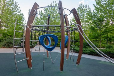 Yeşillik bahçeli bir şehir avlusunda modern oyun alanı ekipmanları