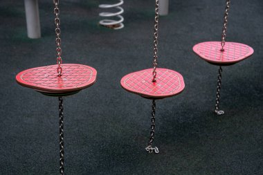 Şehir içi eğlence alanında zincirler tarafından askıya alınmış renkli oyun alanı adım platformları.