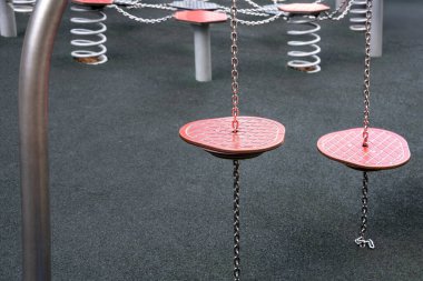 Şehir içi eğlence alanında zincirler tarafından askıya alınmış renkli oyun alanı adım platformları.