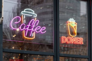 İçinde kahve, kebap ve cam vitrinde sergilenen bardak sembolleri olan neon lambaları. Bu parlak işaretler içecekleri ve yiyecekleri teşvik eder, müşteriler için canlı ve misafirperver bir atmosfer yaratır.
