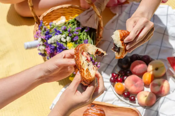Rahat bir piknik ortamında iki kişi bir parça ekmeği paylaşıyor. Bu bir birliktelik, topluluk ve basit zevkleri yakalar. Boş zaman, bağlantı, ya da hayatın anlarının kutlaması