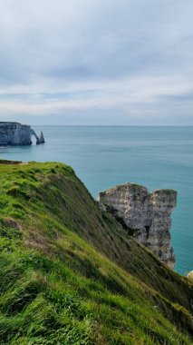 Kemer ve iğneyle Aval uçurumunu Normandiya 'da güneşli bir baharda çakıl taşı plajından görebilirsiniz.