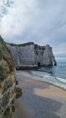 Kemer ve iğneyle Aval uçurumunu Normandiya 'da güneşli bir baharda çakıl taşı plajından görebilirsiniz.