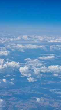 Uçak penceresinden beyaz bulutların ve Dünya 'nın görüntüsü. Seyahat kavramı.