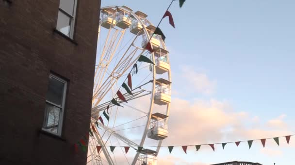 観覧車は灰色の建物を通って開きます 祭りの旗は アイルランドを掛けます キルニー 高品質4K映像 — ストック動画