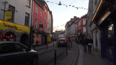 İrlanda 'daki Kilkenny Town Center Caddesi. İnsanlar ve arabalar, restoranlar ve dükkanlar. Geniş açı. Yüksek kalite 4K görüntü. Geniş açı