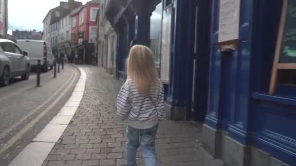 Una Linda Niña Pasea Por Una Calle Del Casco Antiguo — Vídeo de stock