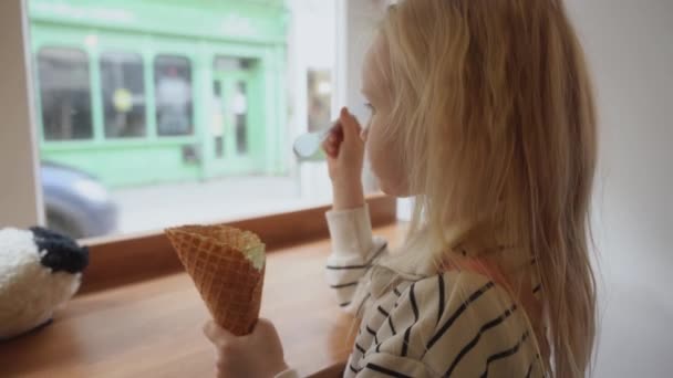 Uma Menina Gira Comer Gelado Num Café Envolve Redor Dos — Vídeo de Stock