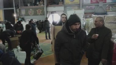 İnsani yardım deposunda gönüllü çalışıyor. Kutular dolusu insani yardım ve Ukrayna için koruma. İkinci el, bağışlanmış şeylerle dolu raflar. İnsani yardım. Yüksek kalite 4k görüntü
