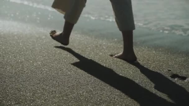 Smukłe Kobiece Nogi Spacerujące Wzdłuż Morskich Fal Wodnych Piaszczystej Plaży — Wideo stockowe