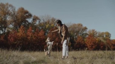Bir kız bir köpeği eğitir. Av köpeği arka ayakları üzerinde zıplar. Sonbahar Konsepti: Köpek insanın en iyi dostudur, hayvanları sever. Kyiv. Ukrayna 2019