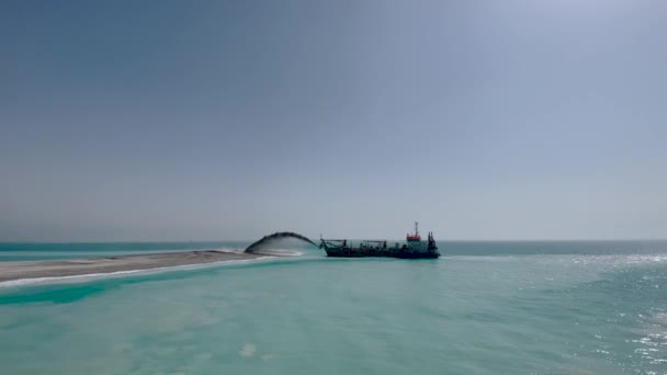 建造船建造了一个新的岛屿 建造人工岛屿 船在岛上撒满了沙子 — 图库视频影像