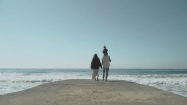 Genç aile iskelede kalıyor. Sevgi dolu ve dost canlısı bir aile kavramı. Ağır çekim 120 Yüksek kalite FullHD görüntü