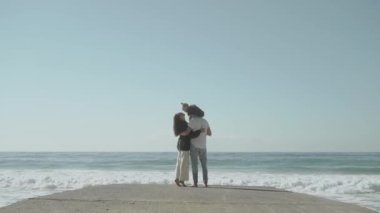 Genç aile iskelede kalıyor. Sevgi dolu ve dost canlısı bir aile kavramı. Ağır çekim 120. Yüksek kalite FullHD görüntüler. 2021