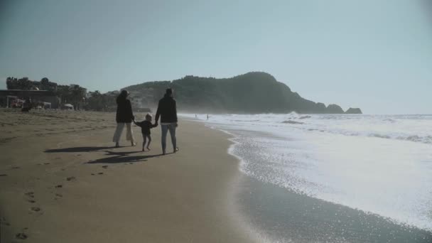 阿拉亚土耳其2021年 年轻的三口之家手牵着手在海滩上走着 背景是美丽的群山 慢动作120高质Fullhd镜头 — 图库视频影像