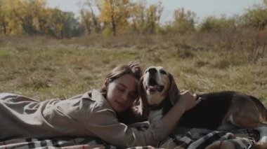Kız çimenlerde uzanıyor, köpeğiyle oynuyor. Bir köpek, insanın en iyi dostudur, hayvanlara olan sevgisidir. Yavaş çekim