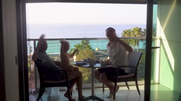 Молодая Семья Ждет Камеры Сидя Балконе Изумительным Видом Море Perfect — стоковое видео