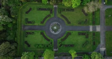 Bir hava gözlemi. Kilkenny Kalesi yakınlarında çarpıcı bir bahçe. İrlanda. Bahçe Nehre bakıyor ve güzel çiçek yatakları, olgun ağaçlar ve çalılar ve merkezi bir çeşme içeriyor.