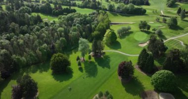 Atış yapmak, golf kulübünün üzerinde uçmak. Tepeleri, kum alanları ve ağaçları olan güzel bir golf sahası. Gün batımı, yaz zamanı, güneş ışığı. Lüks seyahat varış yeri 5k