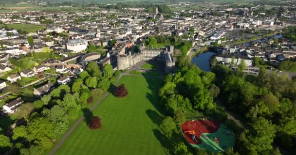 アリアル アイルランドの緑豊かな公園を通ってキルケニー城へのフライト 日の出を背景に ノア川と古代の町 5K形式の高品質のショット — ストック動画