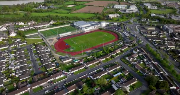 空中だ スポーツの国だ スタジアムは学校に併設されている アイルランドの小さな町のサッカー場の上の円形飛行5Kの映像 — ストック動画