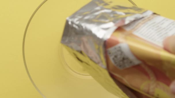 Zeitlupenaufnahmen Von Chips Die Einen Klaren Teller Vor Gelbem Hintergrund — Stockvideo