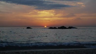 Zaman çizelgeleri. Denizde romantik, renkli bir gün batımı. Güneş batıyor, mavi ve turuncu bulutlar gökyüzünde akıyor. Muhteşem yaz manzarası. Güzellik dünyasını keşfetmek, seyahat, tatil, eğlence. 