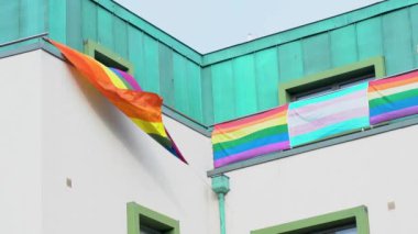Bir ofis binasında çok renkli LGBT bayrağı. LGBT gay gurur bayrağı rüzgarda dalgalanıyor. İrlanda 4k görüntüleri