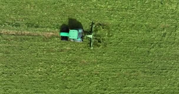 一辆绿色拖拉机驶过一片绿色的草地 割断了草坪 摄像头在它后面移动 — 图库视频影像