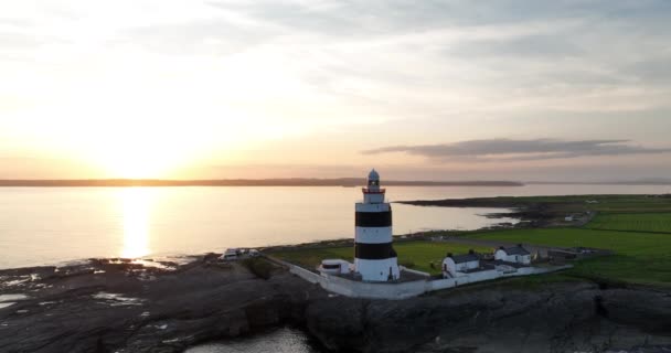 5Kの空中ビュー 大西洋に対する美しい夕日 フック灯台 フックヘッドに位置フック半島の先端にウェックスフォード県 アイルランド5K — ストック動画