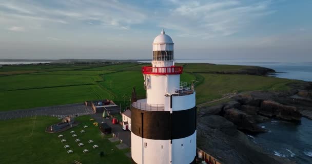 空中だ 閉めろ フック灯台は アイルランドのウェックスフォード郡のフック半島の先端にフックヘッドに位置しています アイルランドの古代灯台の周りの円形のパノラマ — ストック動画
