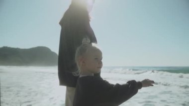 Alanya Türkiye 2021 Anne ve kızı iskelede. Anne kızına eliyle nereye bakacağını gösterir. Kız annesinin işaret ettiği yere bakar. Şirin kız. Yavaş çekim 120