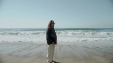 Güzel bir Kleopatra Sahili 'nde duran bir kadın. Tek başıma. Aralık. Hindi. Alanya 2021. Yüksek kaliteli FullHD görüntüler