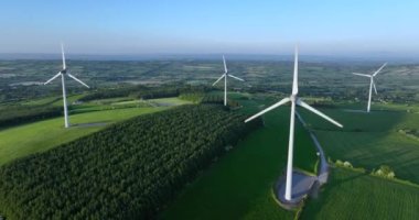 Yükseltilmiş bir bölgedeki güzel mavi gökyüzünde enerji üretimi için bir yel değirmeni çiftliğinin havadan görünüşü. Rüzgar türbinleri sürdürülebilir gelişim için temiz yenilenebilir enerji üretiyor. 5 bin.