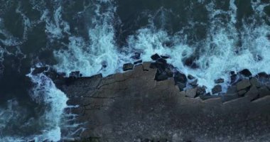 Portekiz, Avrupa 'daki Colares kıyısındaki uçurumların üzerindeki büyük dalgaların görüntüsü. 2023. Fırtınalı havada Atlantik Okyanusu. Köpük dalgaları kayalara çarpıyor. 