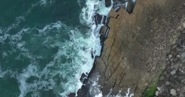 円形の景色 空中トップビュー岩の多い山の高い崖に海の青い波のドローンで5Kの映像が壊れます ビーチでの危険な海の波 — ストック動画