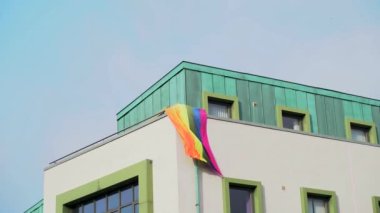 Bir ofis binasında çok renkli LGBT bayrağı. LGBT gay gurur bayrağı rüzgarda dalgalanıyor. İrlanda 4k görüntüleri