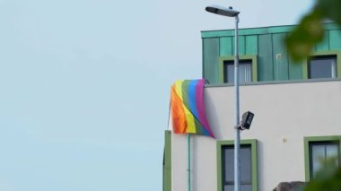 Bir ofis binasında çok renkli LGBT bayrağı. LGBT gay gurur bayrağı rüzgarda dalgalanıyor. İrlanda 4k görüntüleri