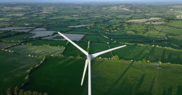 空中だ 緑のフィールドに対するブレードを持つ大規模な風力タービンアイルランドの緑の谷の夕日の空中ビュー代替エネルギー キルケニー アイルランド 高品質5K — ストック動画