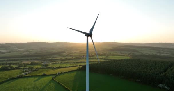 エアリアル アイルランドの緑の谷の日没の代替エネルギーを背景に日没と緑のフィールドの空中ビューのブレードを備えた大型風車 アイルランド 高品質の映像 — ストック動画