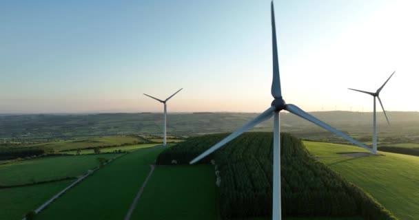 空中だ 日没時に風力タービンが立っている 風力タービンを備えた農場の空中写真 再生可能エネルギーのクリーン化代替エネルギーの創出 キルケニー アイルランド 高品質5K映像 — ストック動画