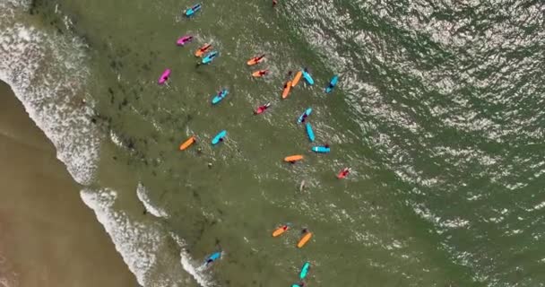 垂直に 海岸で波を練習するサーフィンスクールを持つビーチの円形パノラマ トロモア アイルランド ウォータースポーツコンセプト トロモア アイルランド スローモーション — ストック動画